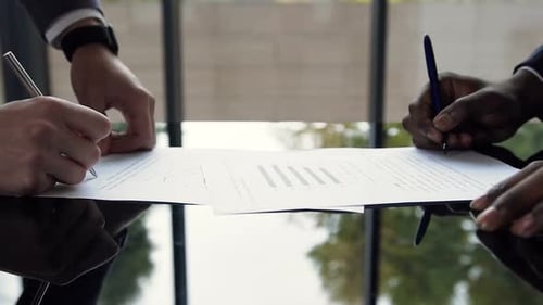 Men Sign Agreement and Shake Hands