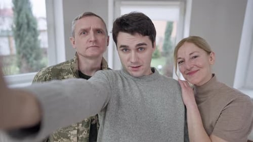 Smiling Family Posing Together For Selfie Indoors