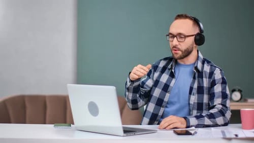 Adult Using Laptop for Virtual Meeting at Desk