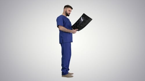Man in Scrubs Examines Brain Scan X-ray