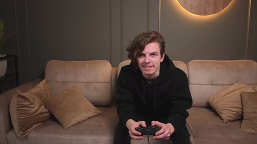 Young Man Plays Video Game on Couch