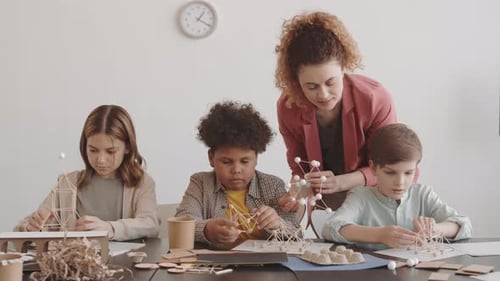 Teacher Watching Children Making Crafts