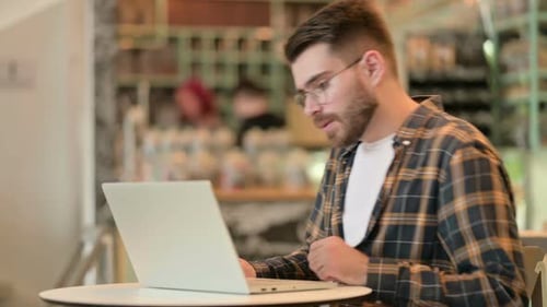 Seriöser männlicher Designer schließt Laptop und geht weg