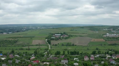 In a Cloudy Summer Day Flying Over a Residential Rural Area