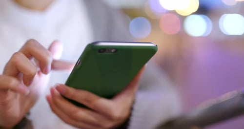 Person Using Smartphone in Urban Night Setting