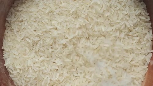 White Rice Grains Being Added to Pile
