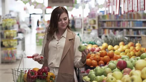 Retail Store, Beautiful Smiling Shopper Woman with Shopping Basket Chooses Eco-friendly Products