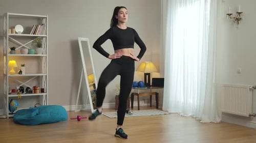 Young Woman Doing Leg Raises at Home