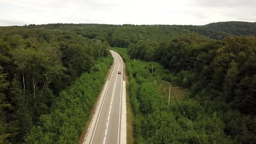 Orange SUV Car Driving on a Rural Road in the Mountains and Forest at Summer Sunny Day - Drone Point