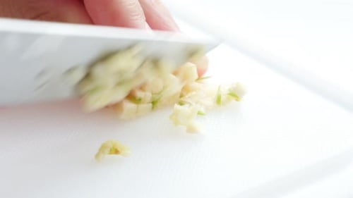 Cutting garlic onion vegetables on plate with knife 4K 2160p UltraHD footage - Garlic onion cut on s