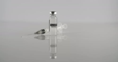 Covid-19 Vaccine Vial and Syringe on Gray