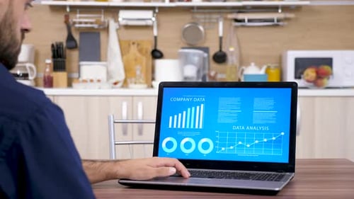 Young Adult Using Laptop with Data Graphs