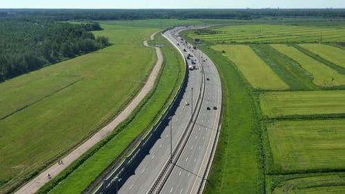 Asphalt Speedway with Cars Through Green Field. Aerial View From Drone