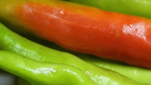 Macro close up of green chili peppers rotating. Static, high angle
