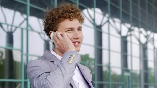 Young Adult Talking on Smartphone Outside Modern Building