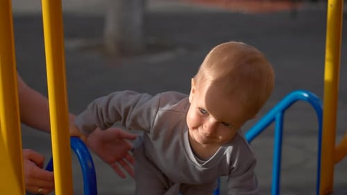 Blond Boy Climbs Metal Structure Installed on Playground