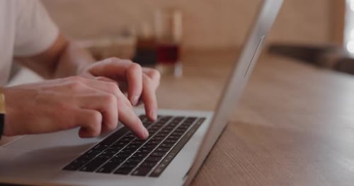 Closeup Male Hands Typing Text on Laptop PC in Cafe