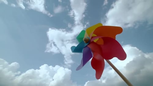 Farbige Papierschraube dreht sich gegen eine blaue Himmelszeitbewegung