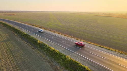 Aerial View of Intercity Road with Fast Driving Cars at Sunset