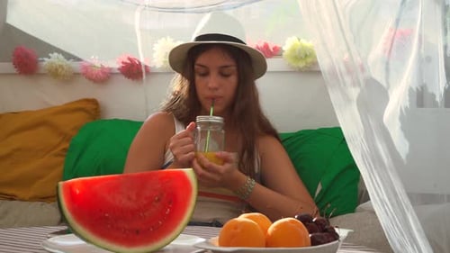 Femme buvant du jus frais du bocal en verre