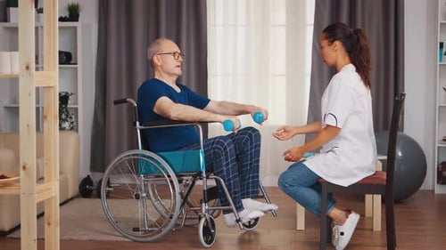 Man in Wheelchair Lifts Weights with Therapist