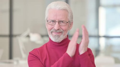 Senior Man Clapping Hands in a Bright Office