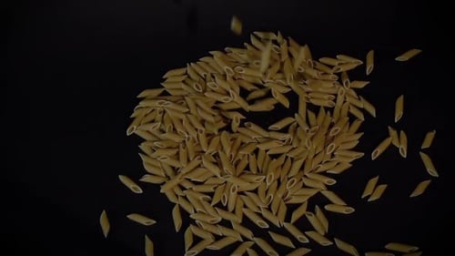 Pasta falling on black surface 100fps slow-motion