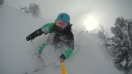 Young man skiing down a snow covered mountain.