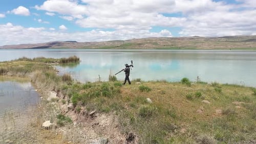 Photographer Walking By The Lake