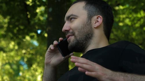Cheerful male in the street on Mobile phone.