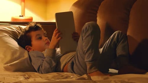 Petit Garçon Se Couche Dans Un Lit Et Touche Sur Une Tablette Pc Le Soir