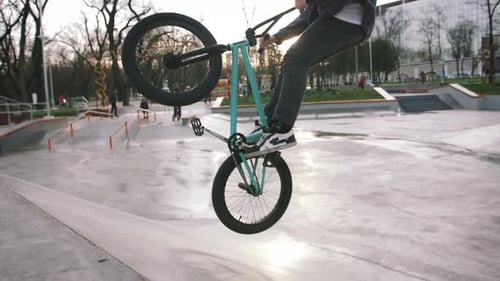BMX Rider Doing Tricks in Street Plaza Bicycle Stunt Rider in Cocncrete Skatepark Super Slow Motion