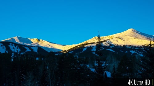 4K Time Lapse of Snow Covered Rocky Mountain Range at Sunrise