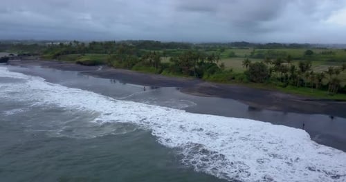 Aerial drone view of a man riding his motocross motorcycle on the beach.