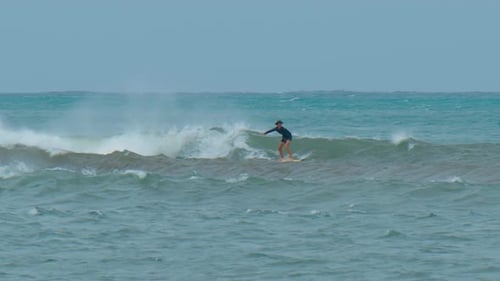 Young Man with Long Hair Rides the Ocean Wave at the Mauritius Surf Spot