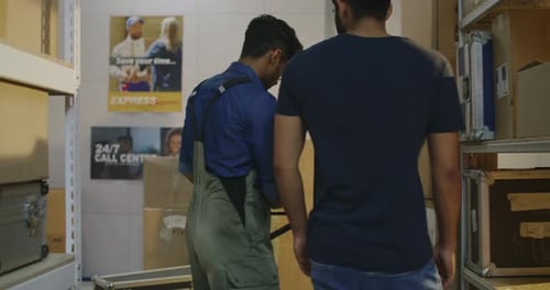 Workers Placing Road Cases on Shelves