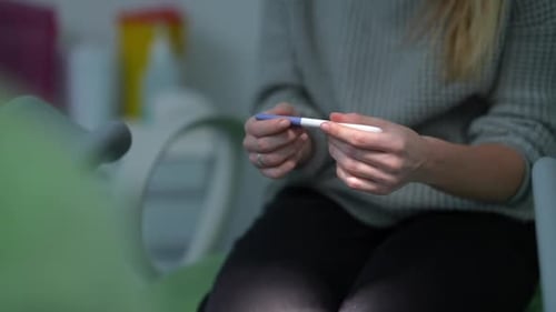 Person Holding Pregnancy Test Waiting For Result