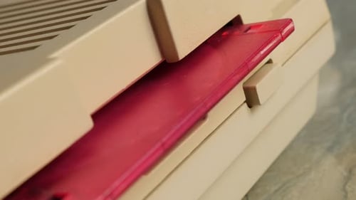 Insertion d'une disquette rose en plastique dans un film UltraHD 4K 2160p d'un ordinateur personnel de style rétro - Disque