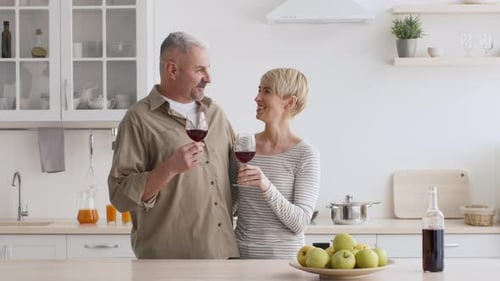 Happy Couple Enjoying Red Wine in Kitchen