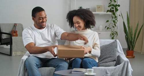 Smiling Couple Opening Delivery Box Together at Home