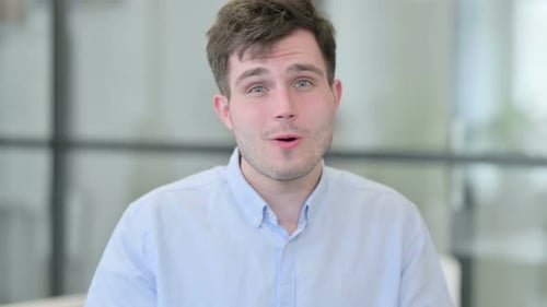 Smiling Man Talking and Waving in Office Setting