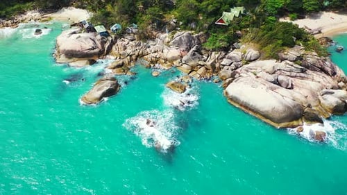 Beautiful scenery with turquoise sea waves splashing on old caved cliffs on shore of tropical island