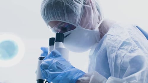 Scientist Using Microscope in Bright Laboratory Setting