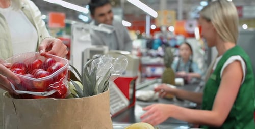 Cashier Scanning Groceries at Supermarket Checkout