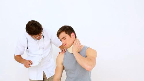 Doctor Examining Patient Wearing Neck Brace