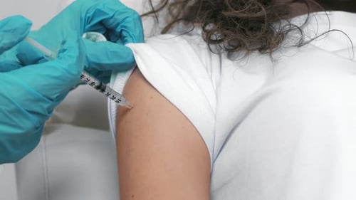 Close Up Shot of Young Woman Getting Coronavirus Vaccination From Doctor at Clinic Slow Motion