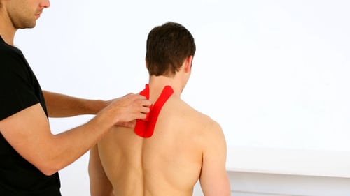 Man Applies Kinesiology Tape for Neck and Back
