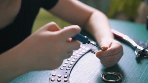 Fashion Designer Attaching Rivets to Belt