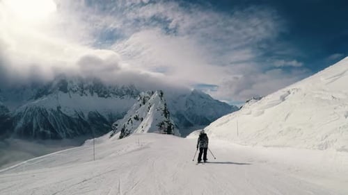 Skier Riding Down Slope in Sunlight