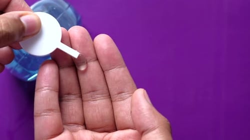 Close Up of Young Man Hand Using Sanitizer Gel for Preventing Virus